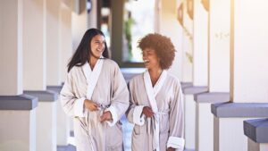 Two women smiling at a day spa.